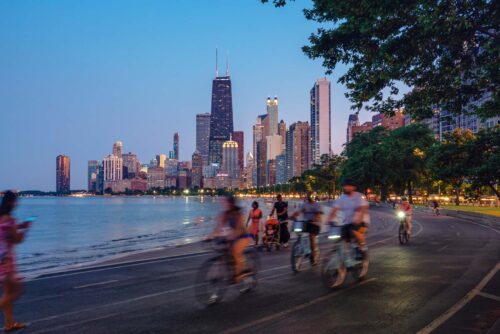 people biking with Chicago skyline in background