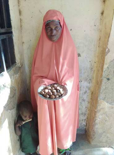 Hafsat Abdullahi processes small batches of local shea nuts into shea butter using traditional preparation methods.