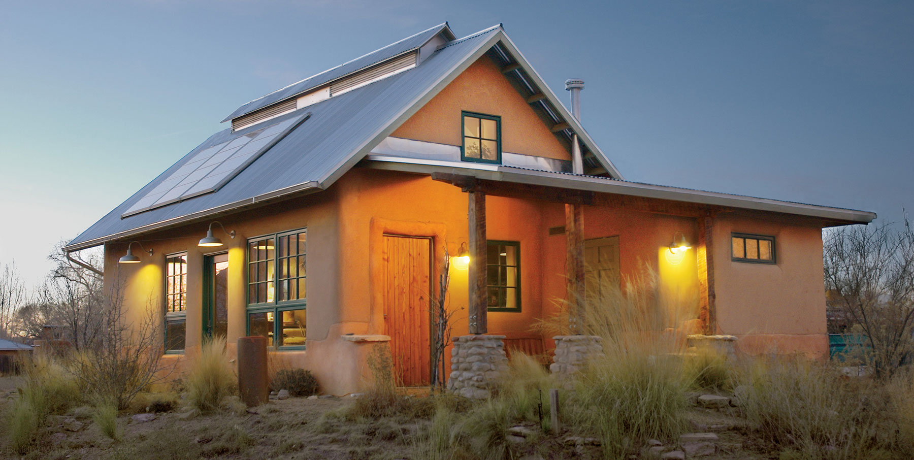 Owens' beautiful and energy-efficient straw bale home at dusk.