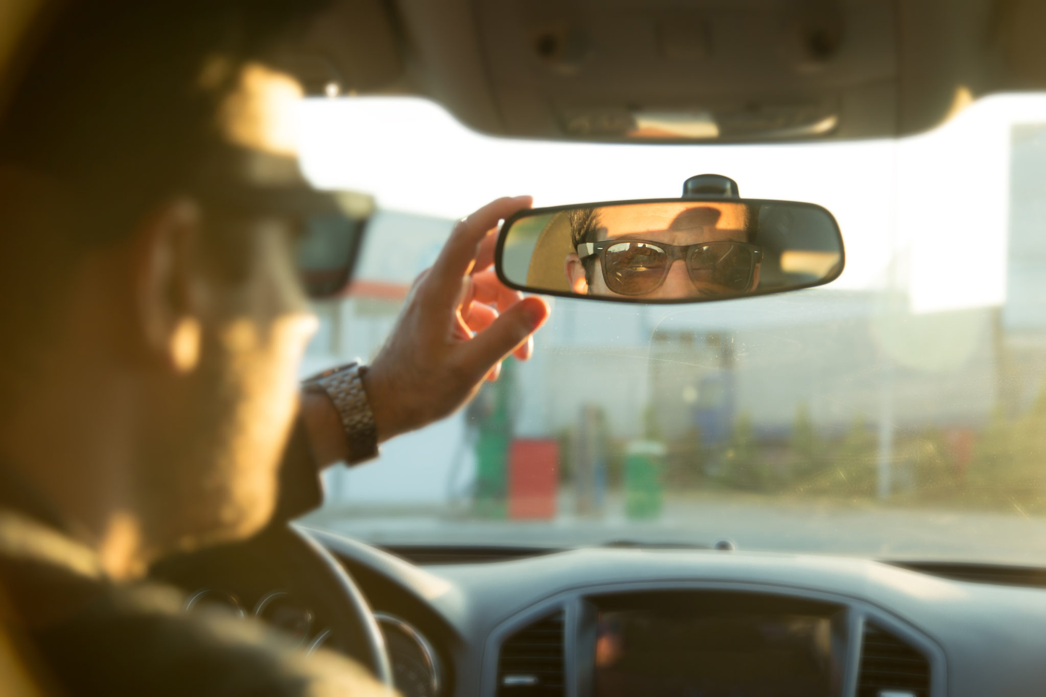 Водитель смотрит в зеркало. Зеркало в машине.