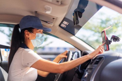 woman driving and using mobile device to navigate