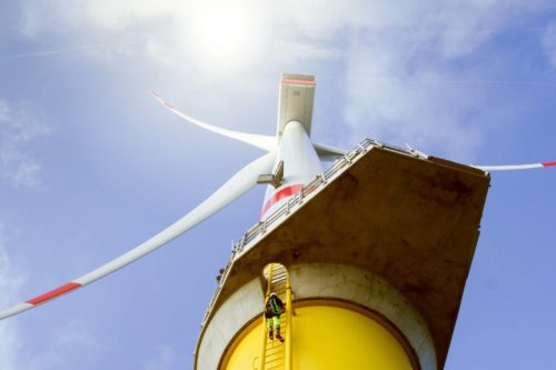 Manual high worker climbing on biggest wind-turbine