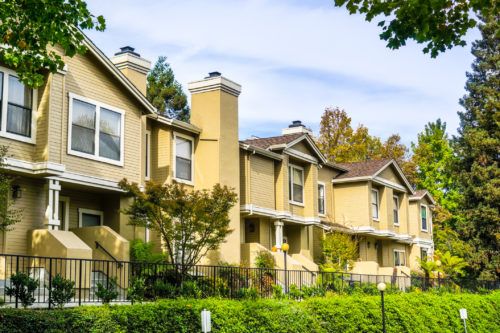 Residential buildings surrounded by trees and hedges