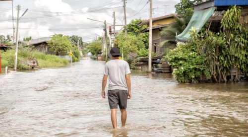 Man walking through a flood on street