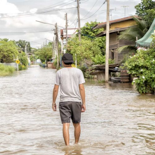Man walking through a flood on street