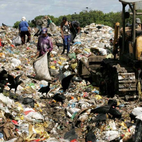 people trawl through landfill