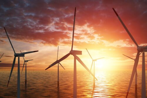 ocean wind turbines at sunset