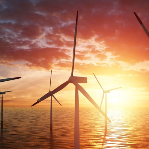 ocean wind turbines at sunset