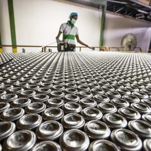 man inspecting aluminum cans