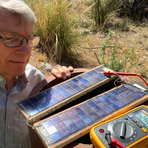 Ted Owens showing off a pair of old solar panels from the 1960s