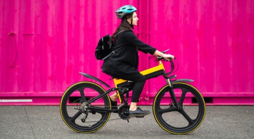 woman riding bike with pink background