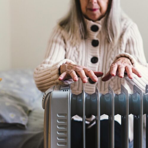 elderly woman uses space heater