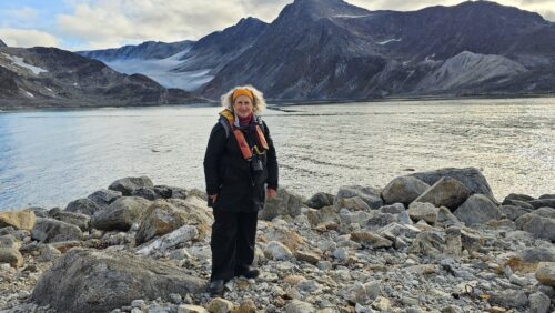 Helen Kessler on a rocky beach with mountains behind