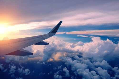 plane wingtip in flight over clouds